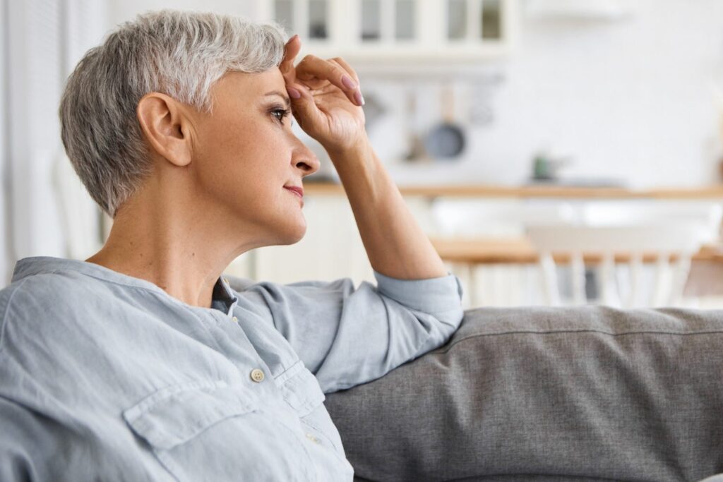 An image of a woman with her elbow bent and a finger against her forehead. Hearing and seeing things that others do not hear or see may indicate the presence of psychosis. Alvarado Parkway Institute offers professional psychosis treatment.